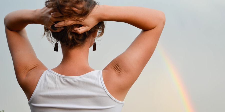 Frau schaut auf Regenbogen