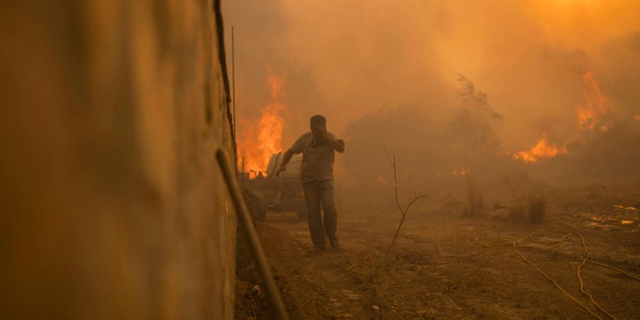 Ein Einheimischer flieht vor den Flammen von einem Waldbrand im Dorf Gennadi auf der griechischen Insel Rhodos.