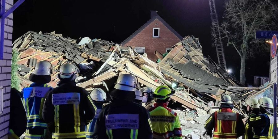 Feuerwehr und Rettungskräfte stehen vor dem eingestürzten Haus im Bochumer Stadtteil Linden.