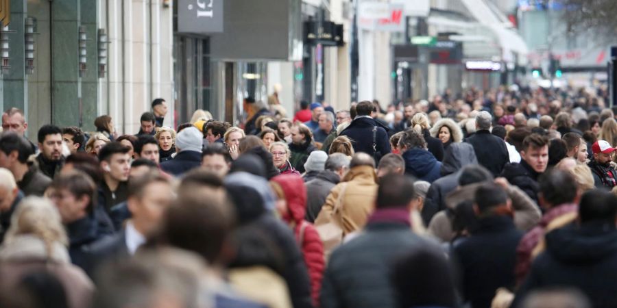 Dicht gedrängt laufen Menschen am Tag vor Heiligabend über die Königsallee in Düsseldorf.