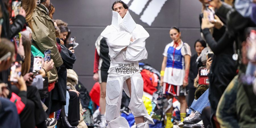 Ein Aktivist bei einer als Adidas-Show getarnten Performance auf dem Catwalk.