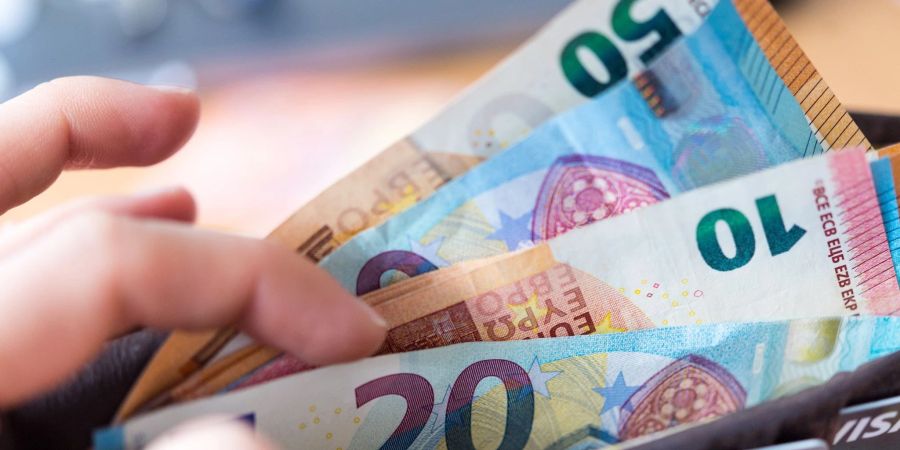 Eine Frau hält eine Geldbörse mit Banknoten in der Hand. 2023 soll es mehr Wohngeld als bislang geben - zudem soll die Beantragung vereinfacht und beschleunigt werden.