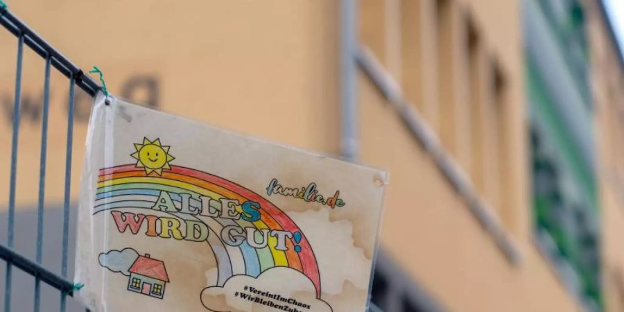 Ein Schild mit den Aufschriften «Alles wird gut!» und «#VereintImChaos» sowie «#WirBleibenZuhause» hängt am Zaun einer Grundschule. Foto: Klaus-Dietmar Gabbert/dpa-Zentralbild/dpa