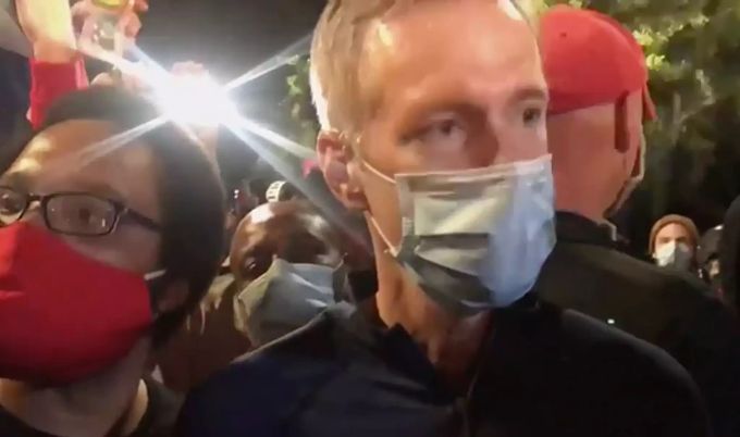 Auf diesem Screenshot aus einem Video trägt Ted Wheeler, Bürgermeister von Portland, einen Mundschutz, während er bei einem Tränengaseinsatz an einem Zaun steht. Proteste in Portland