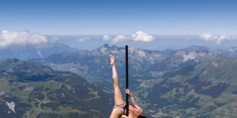 Die italienisch-schweizerische Stangenakrobatin Sheila Nicolodi auf einem Berggipfel in 3000 Metern Höhe. Foto: Laurent Gillieron/KEYSTONE/dpa