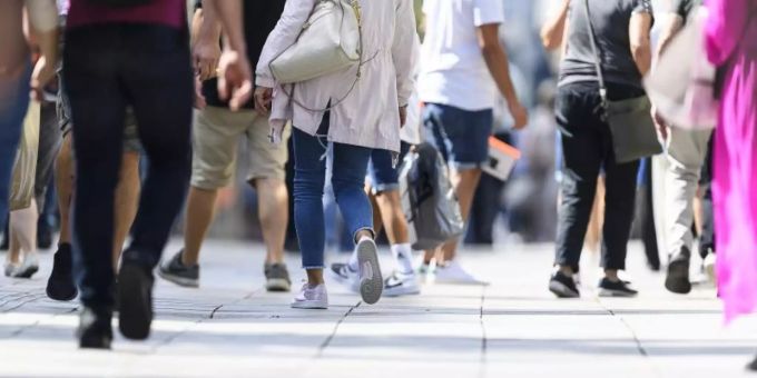 Menschen laufen durch eine Fussgängerzone. deutschland