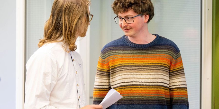 Die angeklagten Klimaaktivisten Lukas Popp (l) und Simon Lachner unterhalten sich vor dem Prozessauftakt.