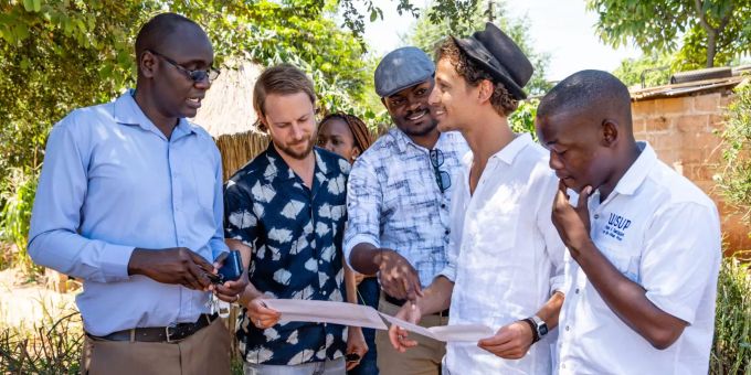 WfW-Gründer Lior und Morris Etter besprechen mit Vertretern der lokalen Behörden und Partnerorganisation den aktuellen Projektstand in Livingstone, Sambia. Männer in Sambia