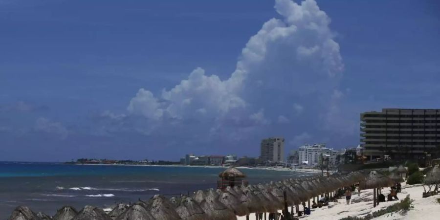 Touristen geniessen den Strand vor der Ankunft des Hurrikans Grace in Cancun im mexikanischen Bundesstaat Quintana Roo. Wegen des herannahenden Hurrikans «Grace» sind im mexikanischen Touristenort Tulum die Hotels evakuiert worden. Foto: Marco Ugarte/AP/dpa