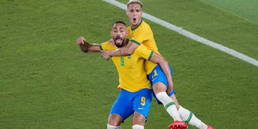 Antony (r) umarmt seinen Mannschaftskameraden Matheus Cunha, nachdem dieser den Führungstreffer erzielt hat. Foto: Martin Mejia/AP/dpa