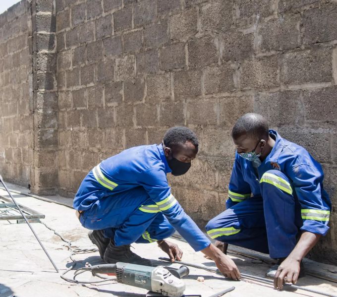 Die nachhaltige Wasserversorgung in der Hauptstadt von Sambia wird dank der WfW-finanzierten Berufsbildung für junge Menschen gefördert. Männer arbeiten