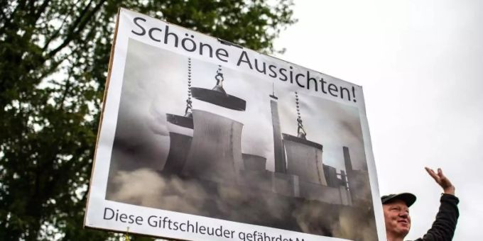 Vor der Verhandlung beim Oberverwaltungsgericht um das Kohlekraftwerk Datteln 4 steht ein Klimaaktivist und protestiert mit einem Plakat. Foto: Guido Kirchner/dpa Vor der Verhandlung beim Oberverwaltungsgericht um das Kohlekraftwerk Datteln 4 steht ein Klimaaktivist und protestiert mit einem Plakat. Foto: Guido Kirchner/dpa