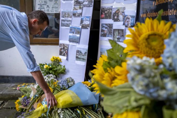 Ein Mann legt am 24. Februar 2023 während einer Mahnwache für die Ukraine in Denpasar, Bali, Blumen nieder. Seit dem Ukraine-Krieg hat die Zahl der Ukrainer und Russen in Bali zugenommen. ukraine krieg