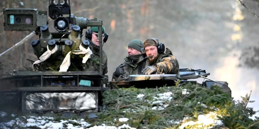 Pistorius (Mitte) auf Panzerfahrzeug in Litauen