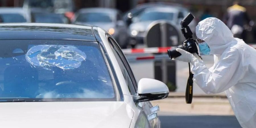 Die Spurensicherung der Polizei fotografiert den beschossenen Mercedes an der Herschelstrasse in Hannover. Foto: Julian Stratenschulte/dpa