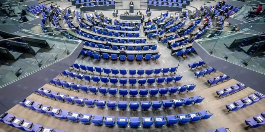 Stühle für die Abgeordneten, aufgenommen im Plenum in Deutschen Bundestag. Auf einigen der Stühle liegen Zettel mit der Aufschrift "Bitte frei lassen". Foto: Michael Kappeler/dpa