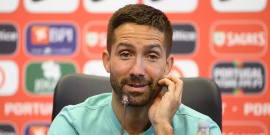 Joao Moutinho sitzt bei der Pressekonferenz im Team-Camp Portugals auf dem Podium. Foto: Robert Michael/dpa-Zentralbild/dpa
