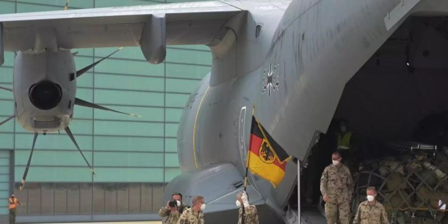 Soldaten der Bundeswehr betreten mit ihrer Truppenfahne deutschen Boden. Foto: Hauke-Christian Dittrich/dpa