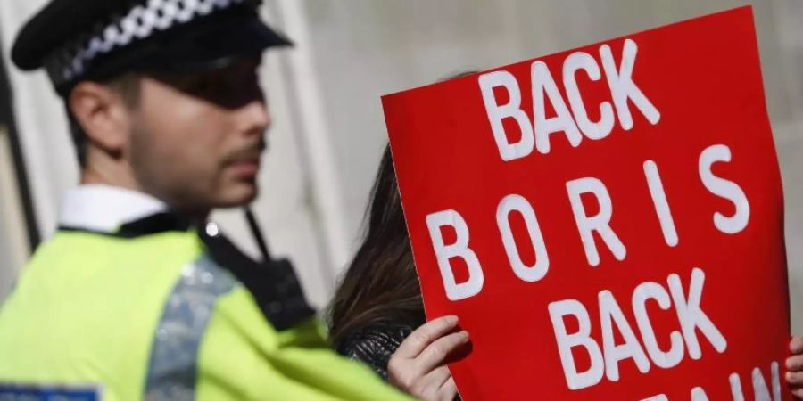 Ein Polizist steht neben einem Pro-Brexit-Demonstranten in London. Premier Boris Johnson will vor allem eine Änderung beim Backstop erreichen. Foto: Alastair Grant/AP