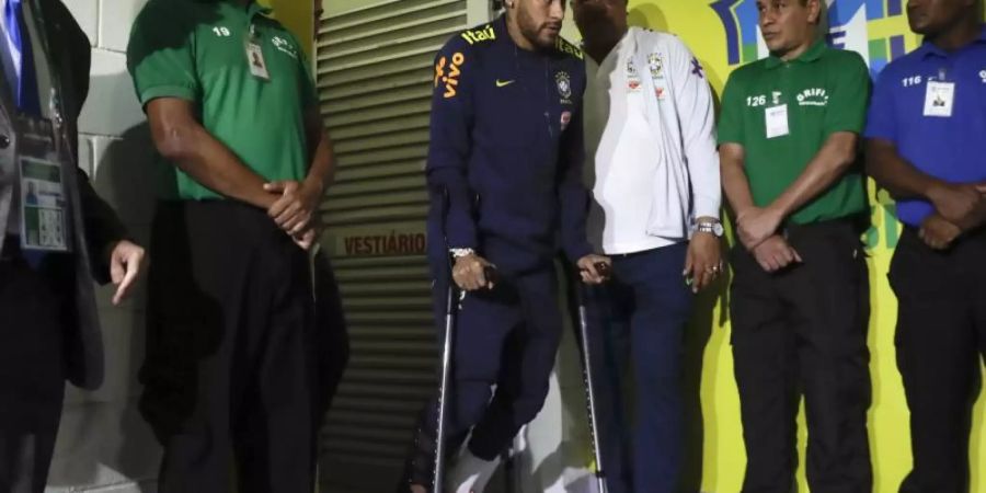 Neymar (M) verlässt die Umkleidekabine der Brasilianer an Krücken, nachdem er sich während des Spiels gegen Katar verletzt hat. Foto: Andre Penner/AP