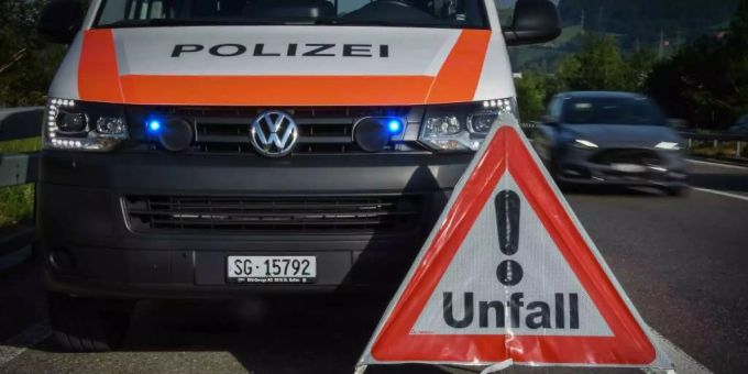 Ein Einsatzwagen der Polizei steht hinter einem Warndreieck mit der Aufschrift «Unfall». Verkehrsunfall