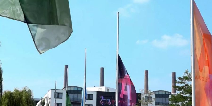 Die Fahnen in der Autostadt Wolfsburg hängen auf Halbmast. Foto: Peter Steffen