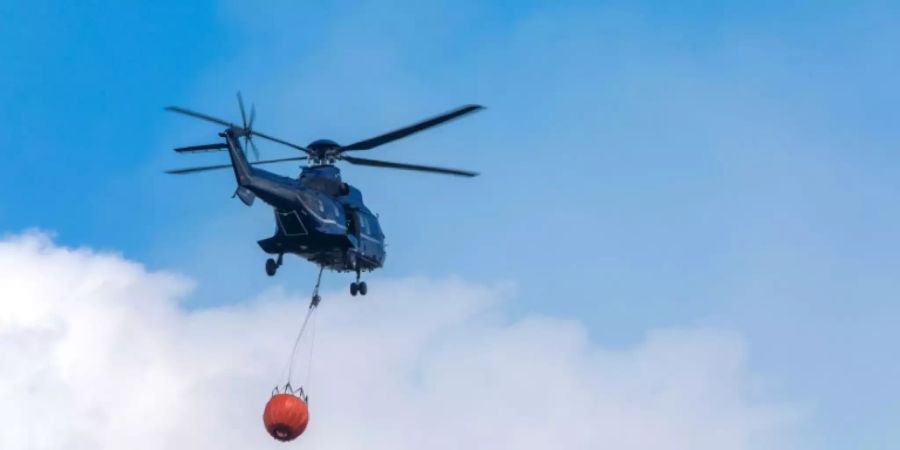 Polizeihubschrauber transportiert Löschwasser