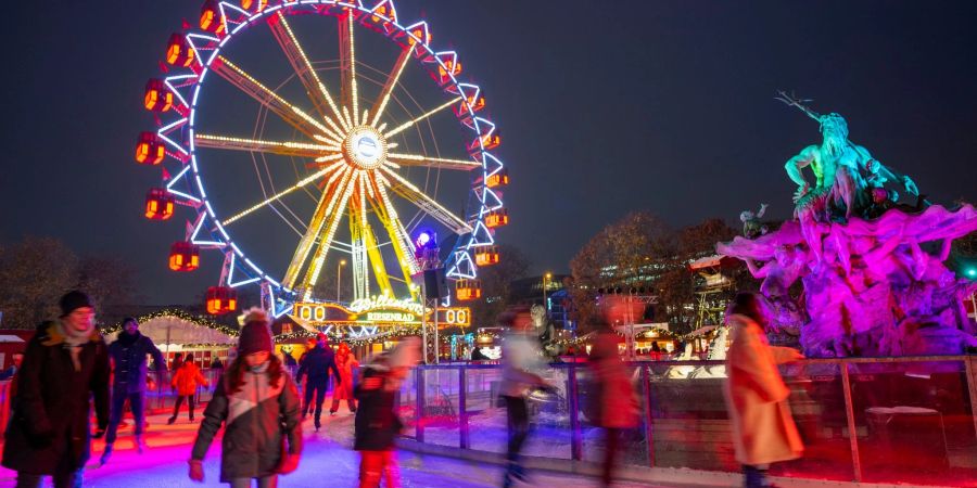 Zahlreiche Menschen fahren mit ihren Schlittschuhen auf einer Eisfläche auf dem Weihnachtsmarkt «Berliner Weihnachtszeit» am Roten Rathaus.
