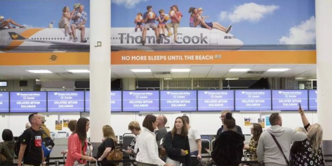 Reisende vor einem Schalter der britischen Thomas Cook Group. Thomas Cook Group