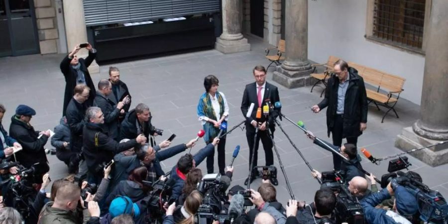 Umringt von Kameras und Mikrofonen: Eva-Maria Stange (SPD, l), Wissenschaftsministerin von Sachsen, und Roland Wöller (CDU, r), Innenminister von Sachsen, bei einer Pressekonferenz im Kleinen Schlosshof des Residenzschlosses in Dresden. Foto: Sebastian Kahnert/dpa-Zentralbild/dpa