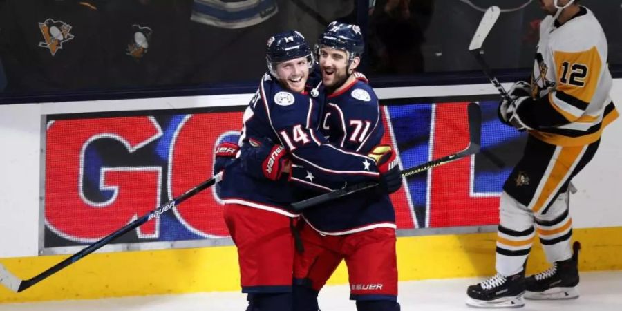 Gustav Nyquist (l) und Nick Foligno von den Columbus Blue Jackets feiern den Sieg gegen die Pittsburgh Penguins. Foto: Paul Vernon/AP/dpa