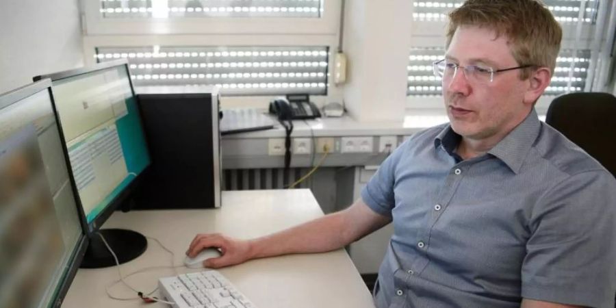 Achim Holzmann, Ermittler des Polizeipräsidiums Heilbronn im Bereich Kinderpornografie, sichtet Bildmaterial. Foto: Sina Schuldt/dpa