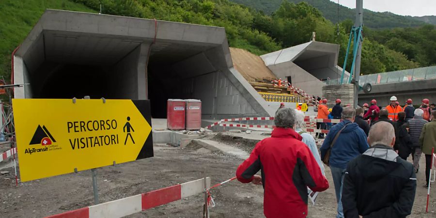 Besucher mit Schutzhelmen machen sich am Tunnelportal bereit für die Besichtigung im Ceneri Tunnel. (Archivbild)