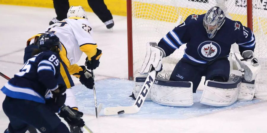 Der Schweizer Kevin Fiala prüft Jets-Goalie Connor Hellebuyck.