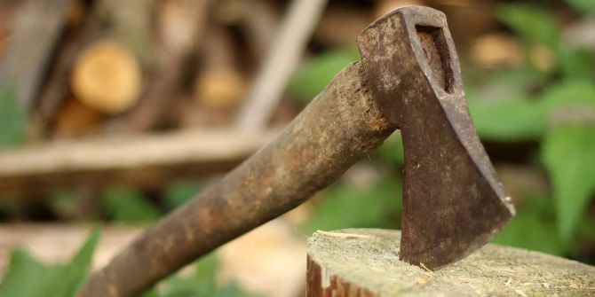 Ein Beil steckt in einem Stück Holz.