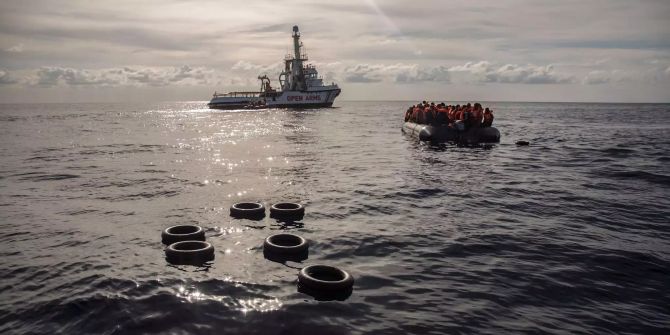 Migranten sitzen in einem Schlauchboot.