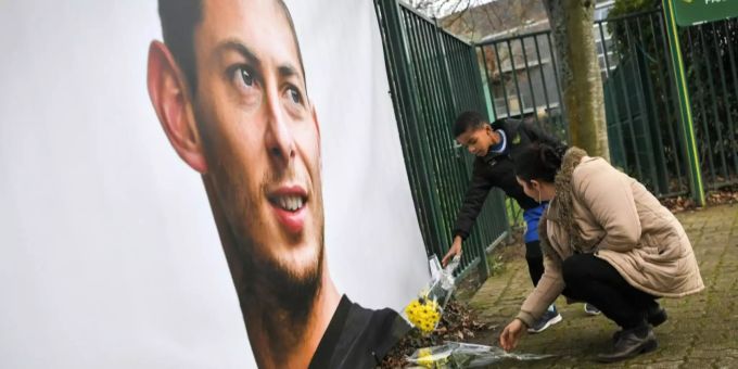 Menschen legen in Nantes Blumen vor eine Abbildung Salas.