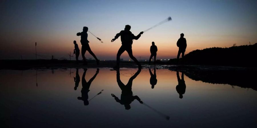 Palästinenser nutzen in Gaza Steinschleudern bei Auseinandersetzungen mit Soldaten aus Israel.