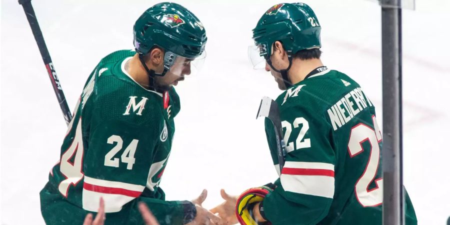 Nino Niederreiter (rechts) und Matt Dumba feiern einen Treffer der Minnesota Wild mit einem Handshake.