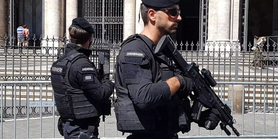 Zwei schwer bewaffnete, italienische Polizisten patrouillieren durch Rom.