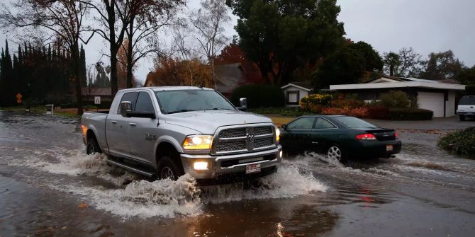 Zwei Wagen fahren auf einer überfluteten Strasse in Chico, Kalifornien (USA) aneinander vorbei.