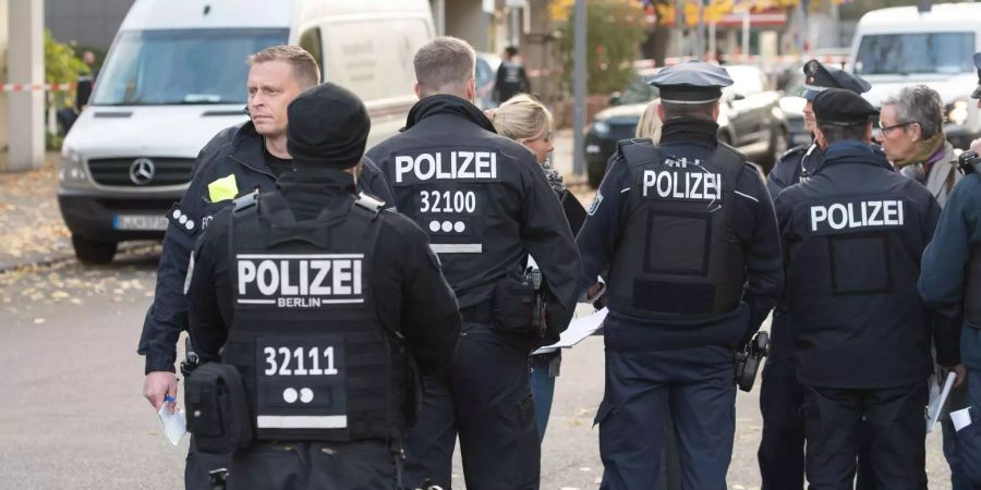 Polizisten stehen nahe der Stelle, an der mehrere Maskierte am Morgen einen Geldtransporter überfallen haben.