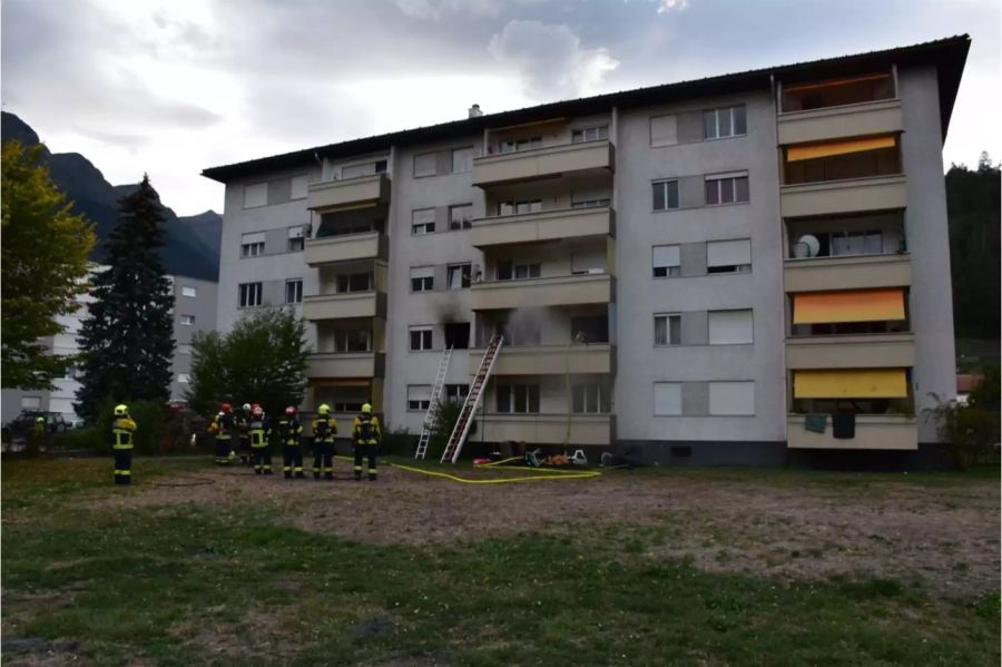 Aus dem betroffenen Mehrfamilienhaus in Thusis steigt Rauch aus dem ersten Stock.