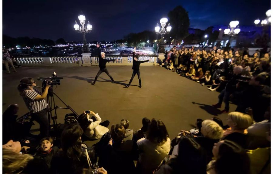 Der französische Tänzer und Choreograph Marie-Claude Pietragalla tanzt während einer Aufführung auf der Pont Alexandre III-Brücke über der Seine als Teil der Nuit Blanche in Paris.