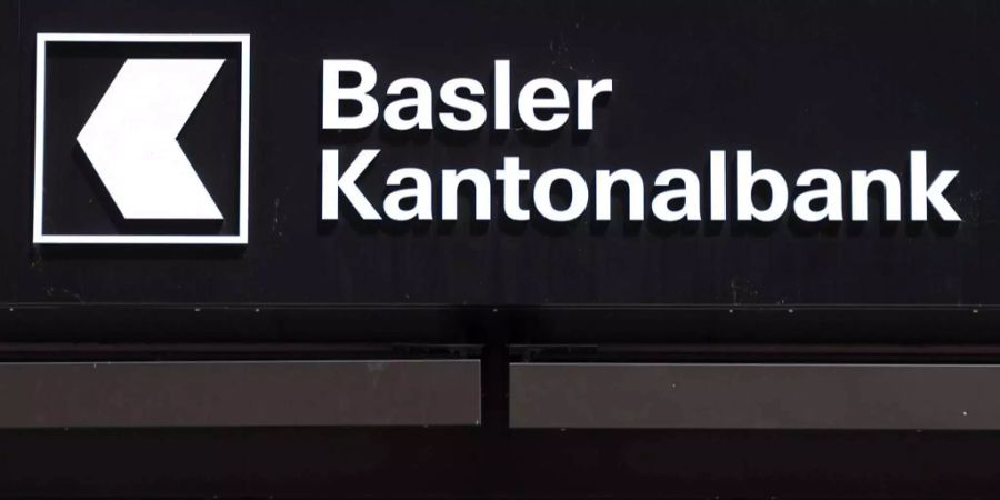 Das Logo der Basler Kantonalbank hängt über dem Eingang einer Filiale.