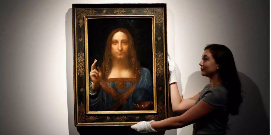 Eine Mitarbeiterin posiert mit Leonardo da Vincis «Salvator Mundi» in London.