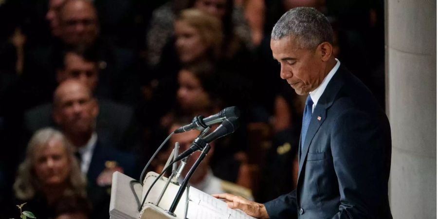 Barack Obama hält mit gesenktem Blick eine Trauerrede für den verstorbenen John McCain.