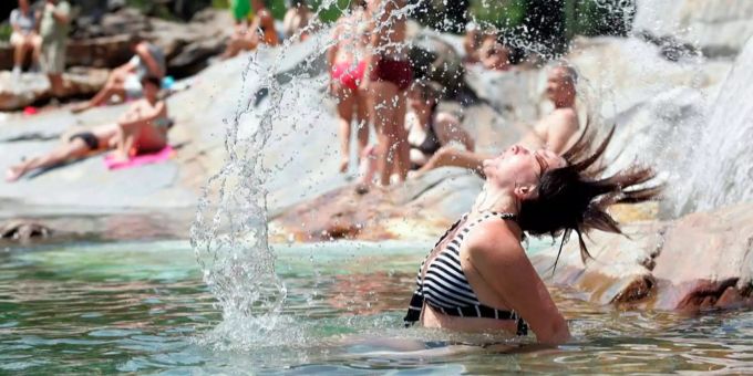 Eine Frau geniesst das Wetter in einem Schwimmbad – viele Badis in der Schweiz sind bereits offen. polarkreis 34 Grad wetter