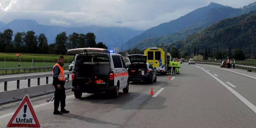 Polizisten sperren die Strasse ab, um sich um die Verletzten eines Autounfalls zu kümmern.