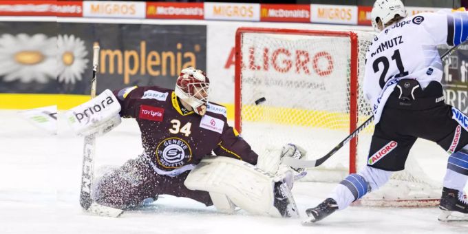 Genf-Goalie Gauthier Descloux kämpft gegen Freiburg-Stürmer Flavio Schmutz um den Puck. Genf-Goalie Gauthier Descloux kämpft gegen Freiburg-Stürmer Flavio Schmutz um den Puck.